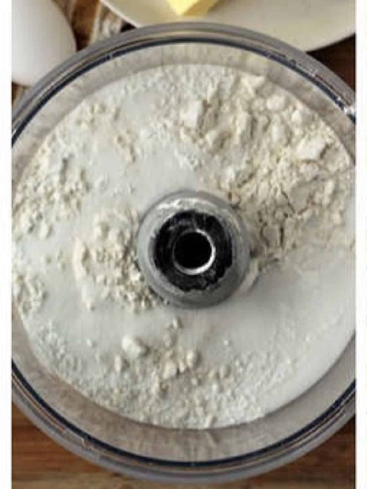 Flour, sugar and salt in bowl of food processor for ricotta pie dough.