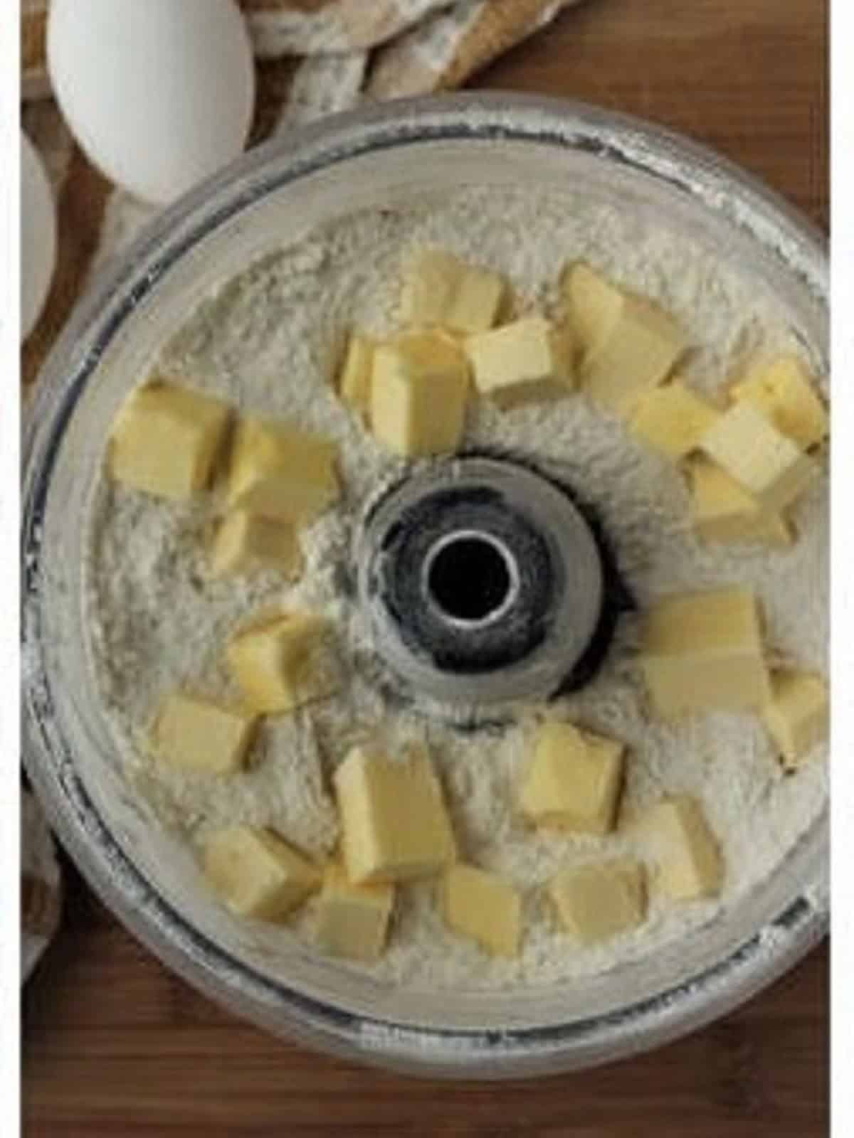 Cubed butter added to dry ingredients for ricotta pie dough.