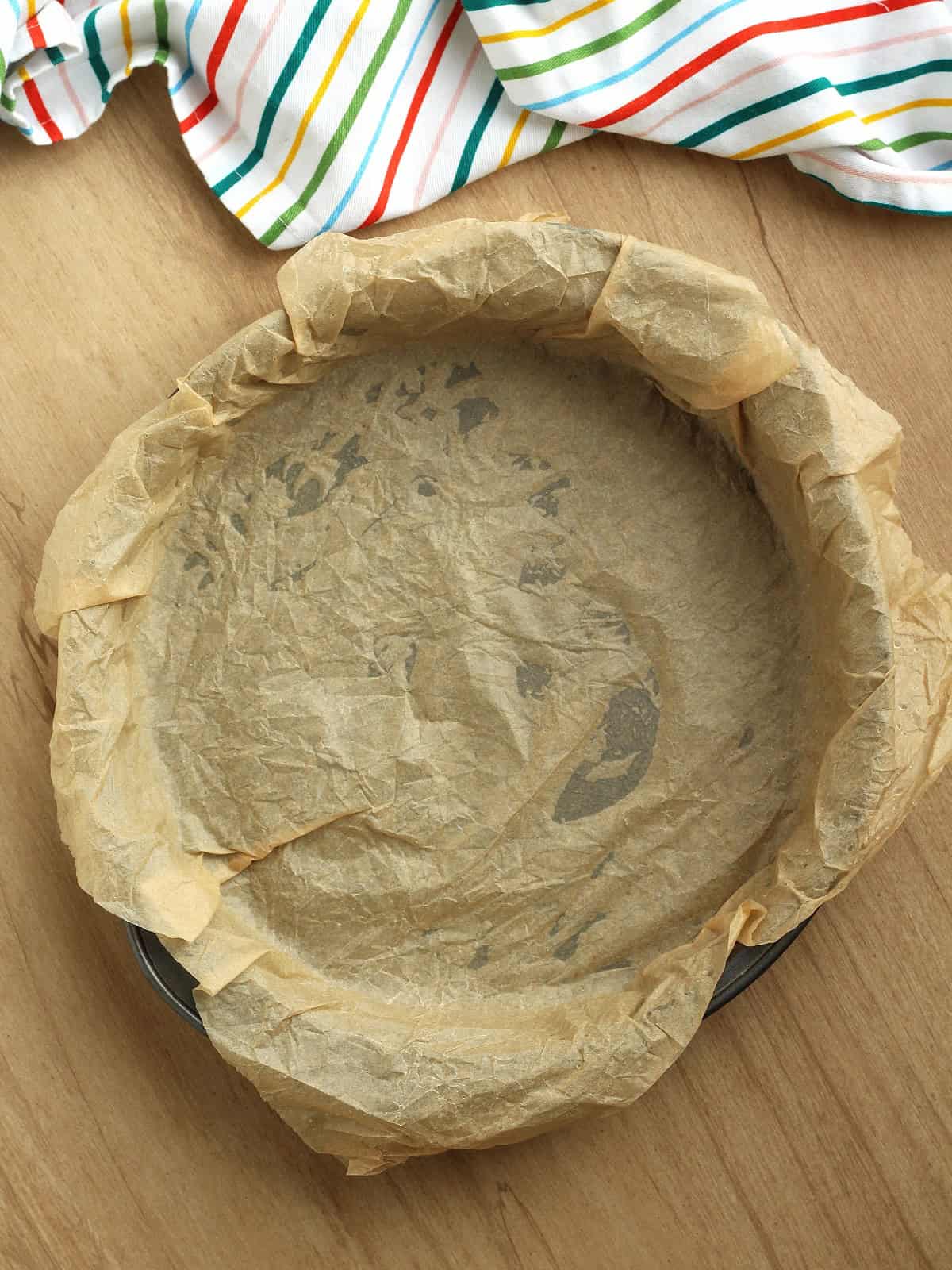 Cake pan covered with parchment paper for whole orange cake.