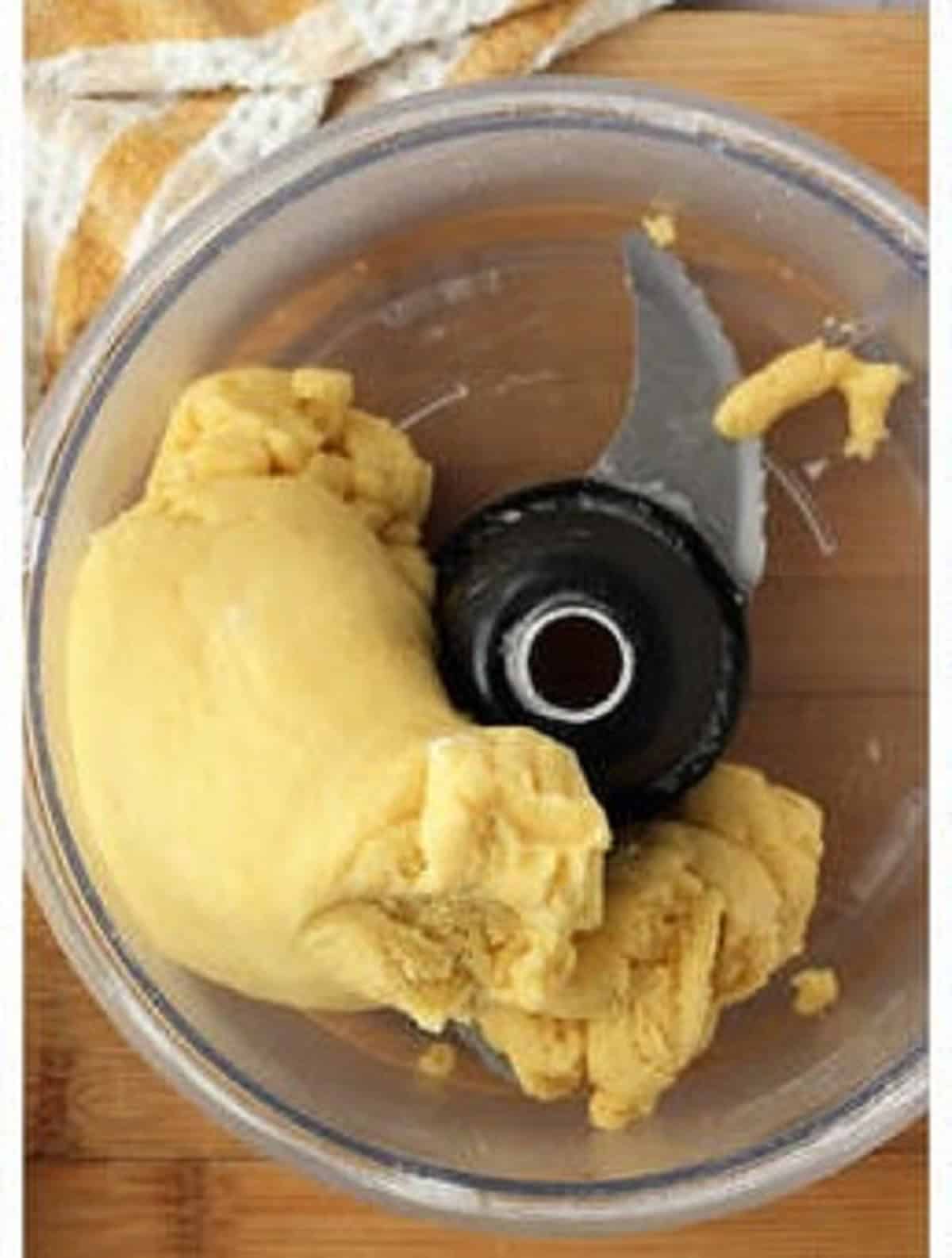 Ricotta pie dough wrapped around food processor bowl blade.