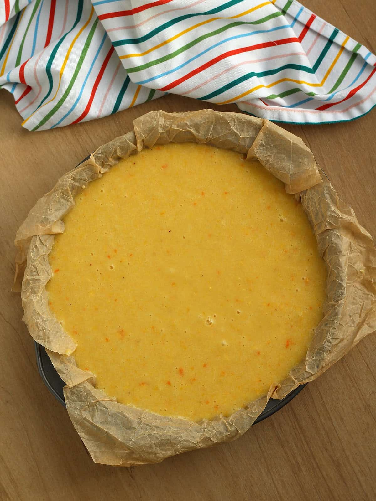 Sicilian pan d'arancio cake batter in cake pan lined with parchment paper.