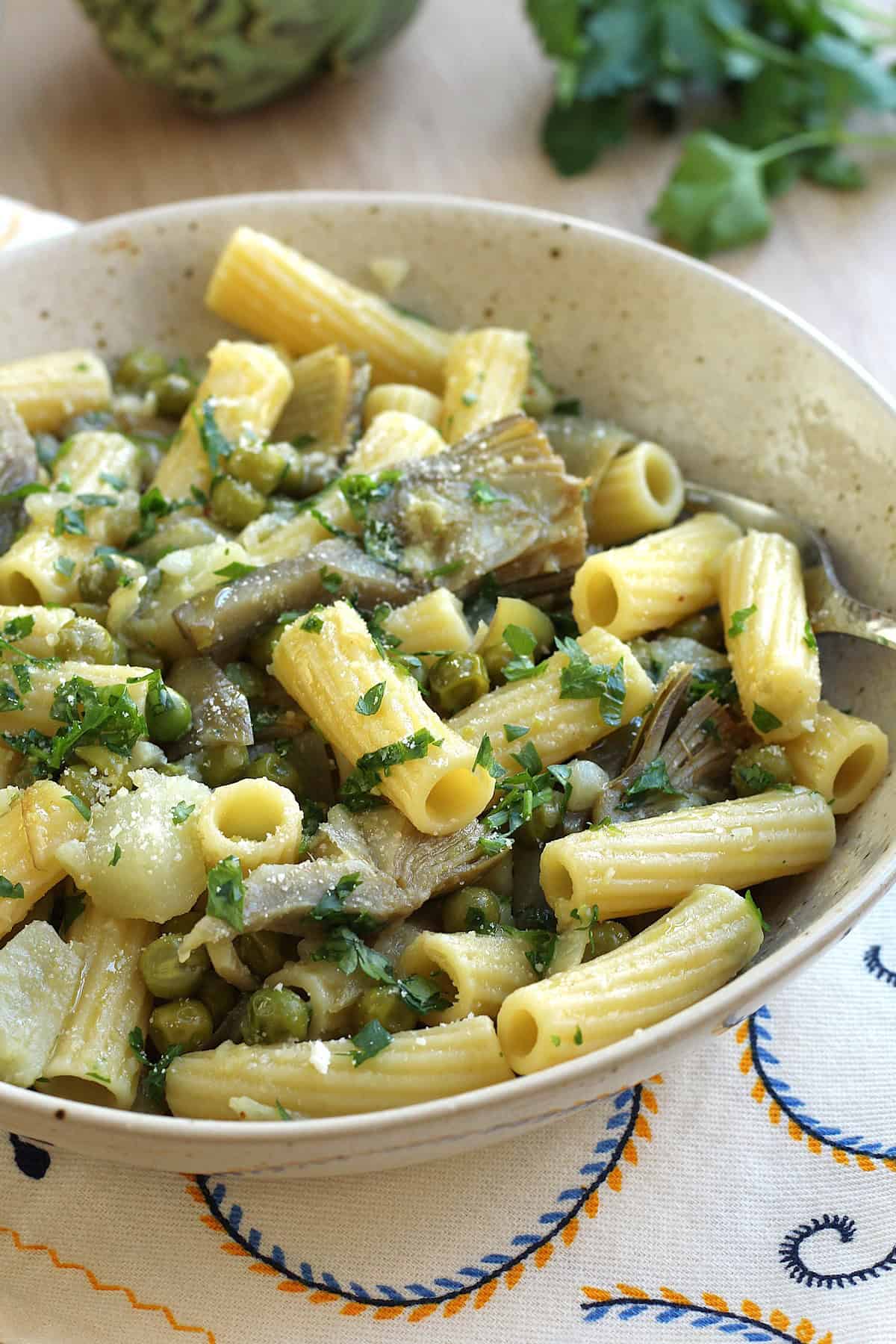 Bowl of Italian pasta with artichokes and peas.