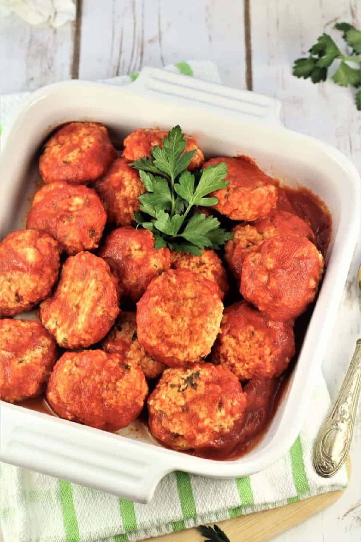 Italian meatless meatballs in tomato sauce in white dish.