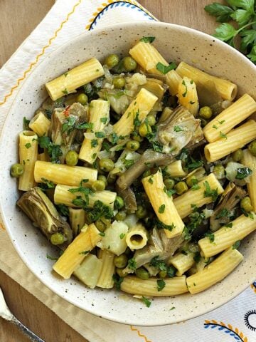 Bowl of artichoke pasta with peas and potatoes.