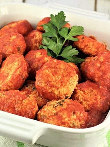 Italian meatless meatballs, polpette di pane, in casserole dish with fresh parsley.