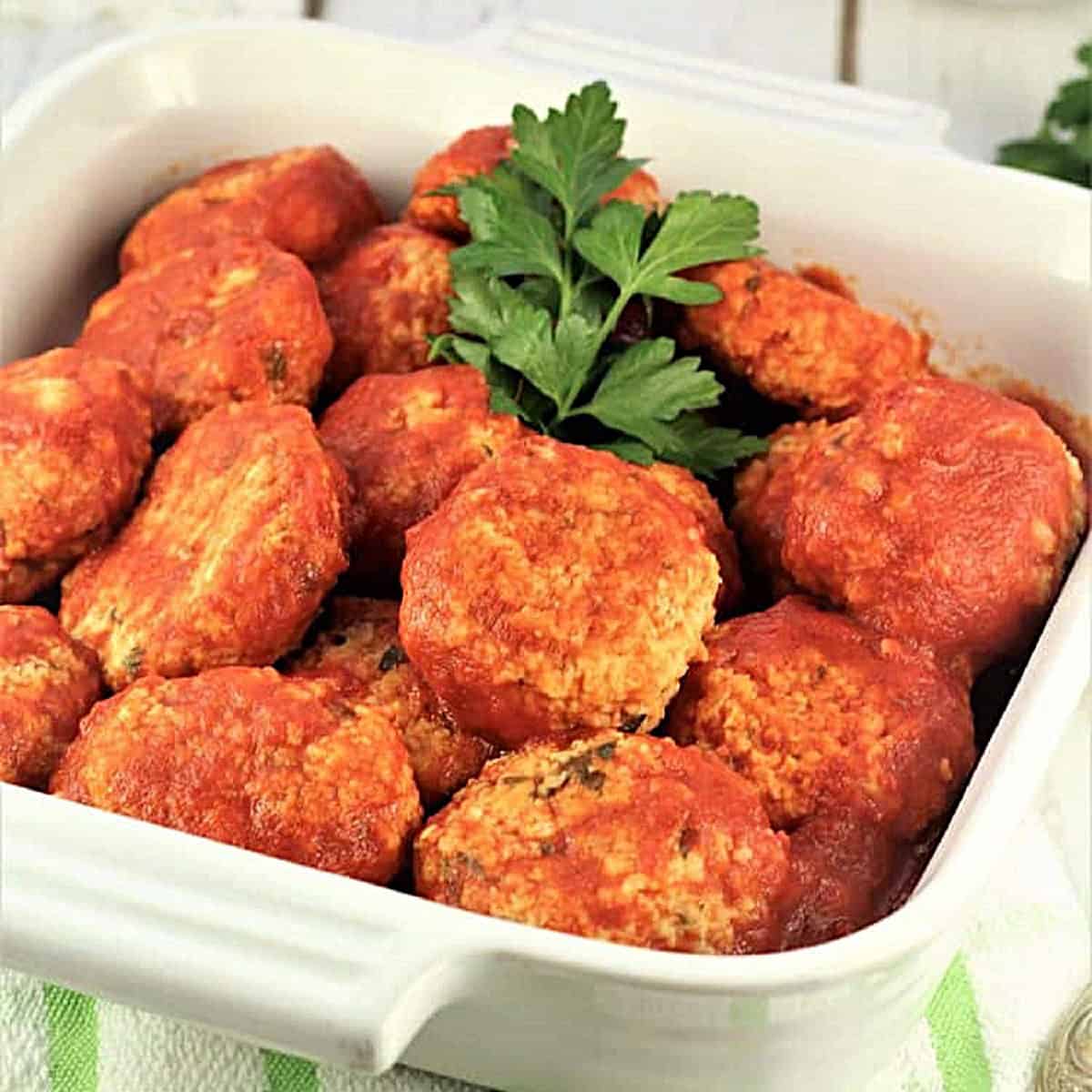 Italian meatless meatballs, polpette di pane, in casserole dish with fresh parsley.
