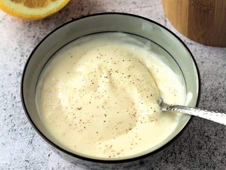 Garlic aioli sauce in bowl with spoon.