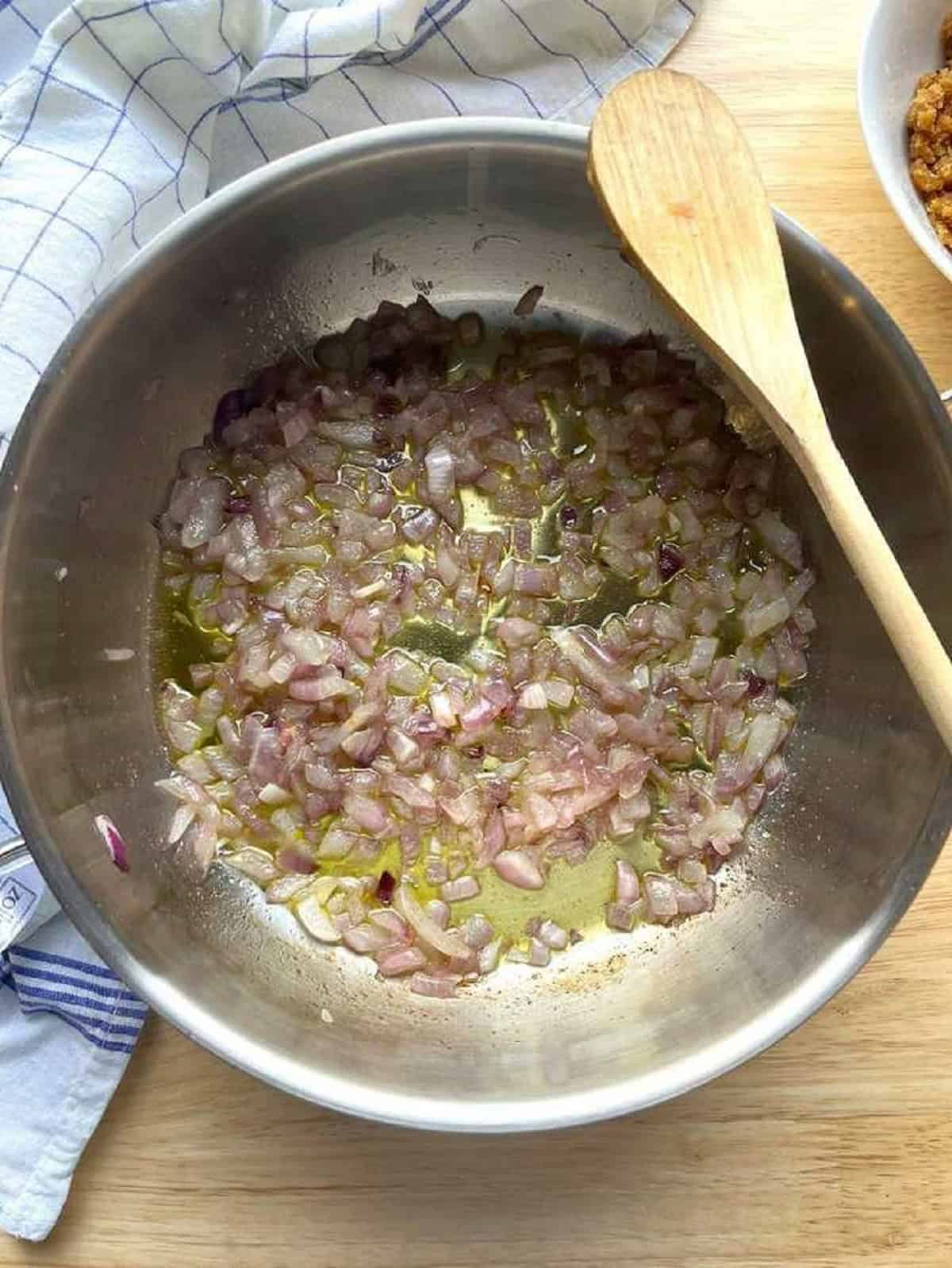 Onion sautéed in olive oil in skillet for wild fennel pasta.