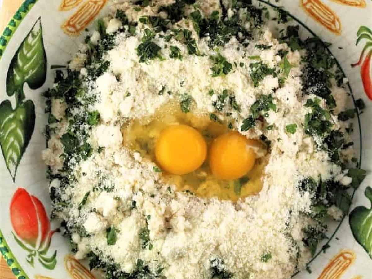 Breadcrumbs, eggs, parsley, cheese and minced garlic in bowl for meatless meatballs.