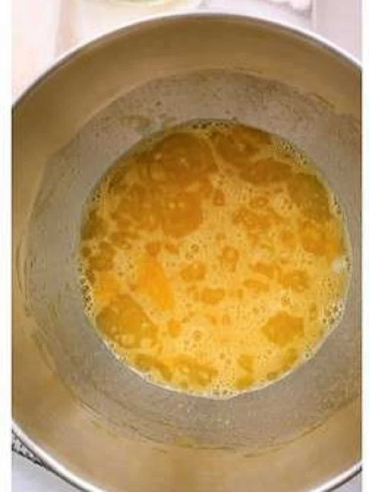 Beaten eggs with butter in food processor bowl for Easter bread recipe.