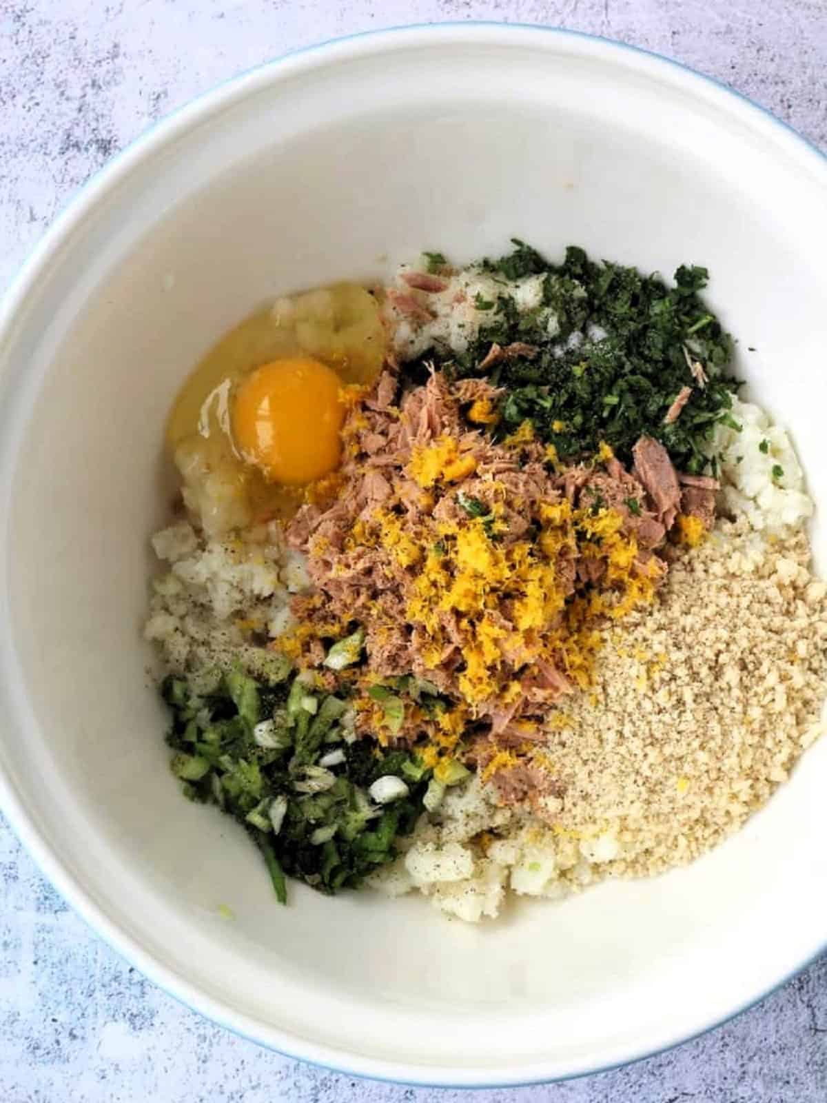 Ingredients for tuna potato patties in large bowl.