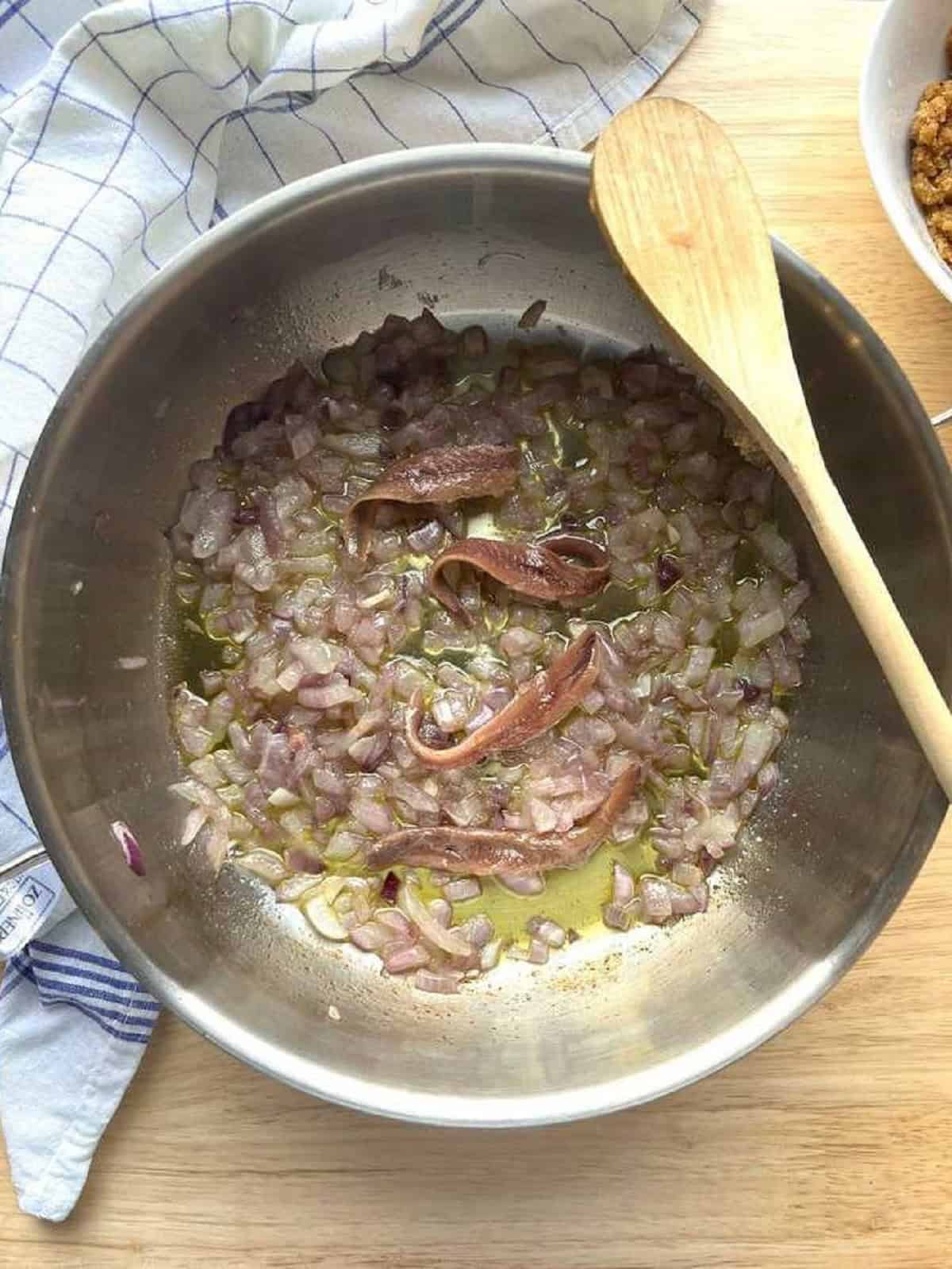 Anchovies added to skillet with onion for wild fennel pasta.