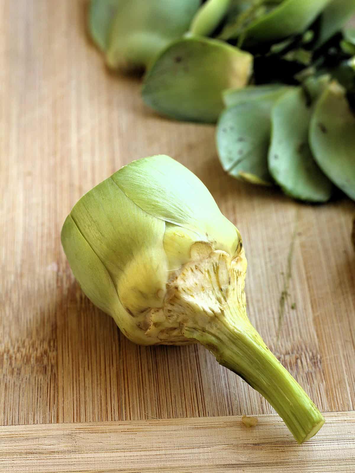 Artichoke with layer of tough stem removed.