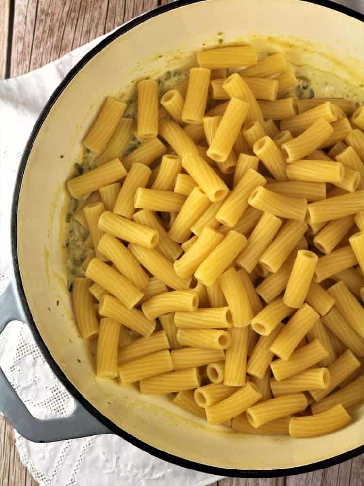Pasta added to skillet with pistachio sauce.