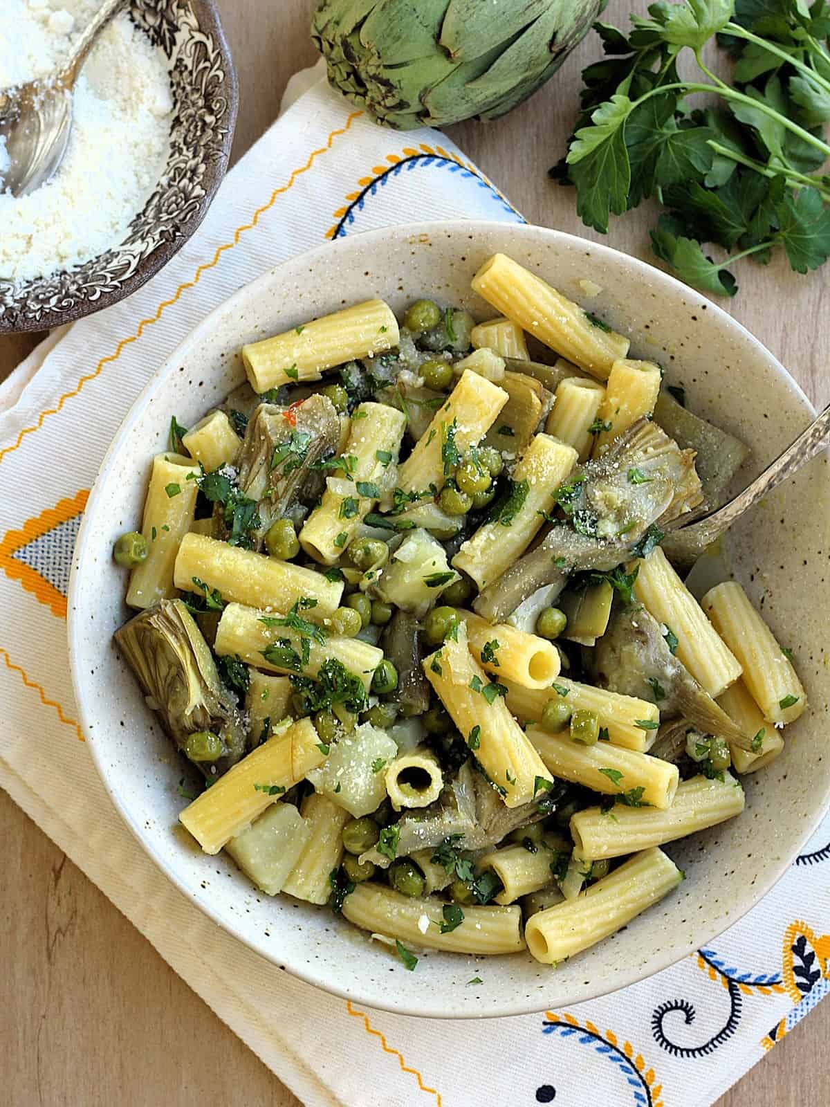 Bowl of pasta with artichokes, peas and potatoes.