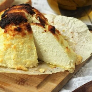 Baked ricotta al forno with wedge cut out.