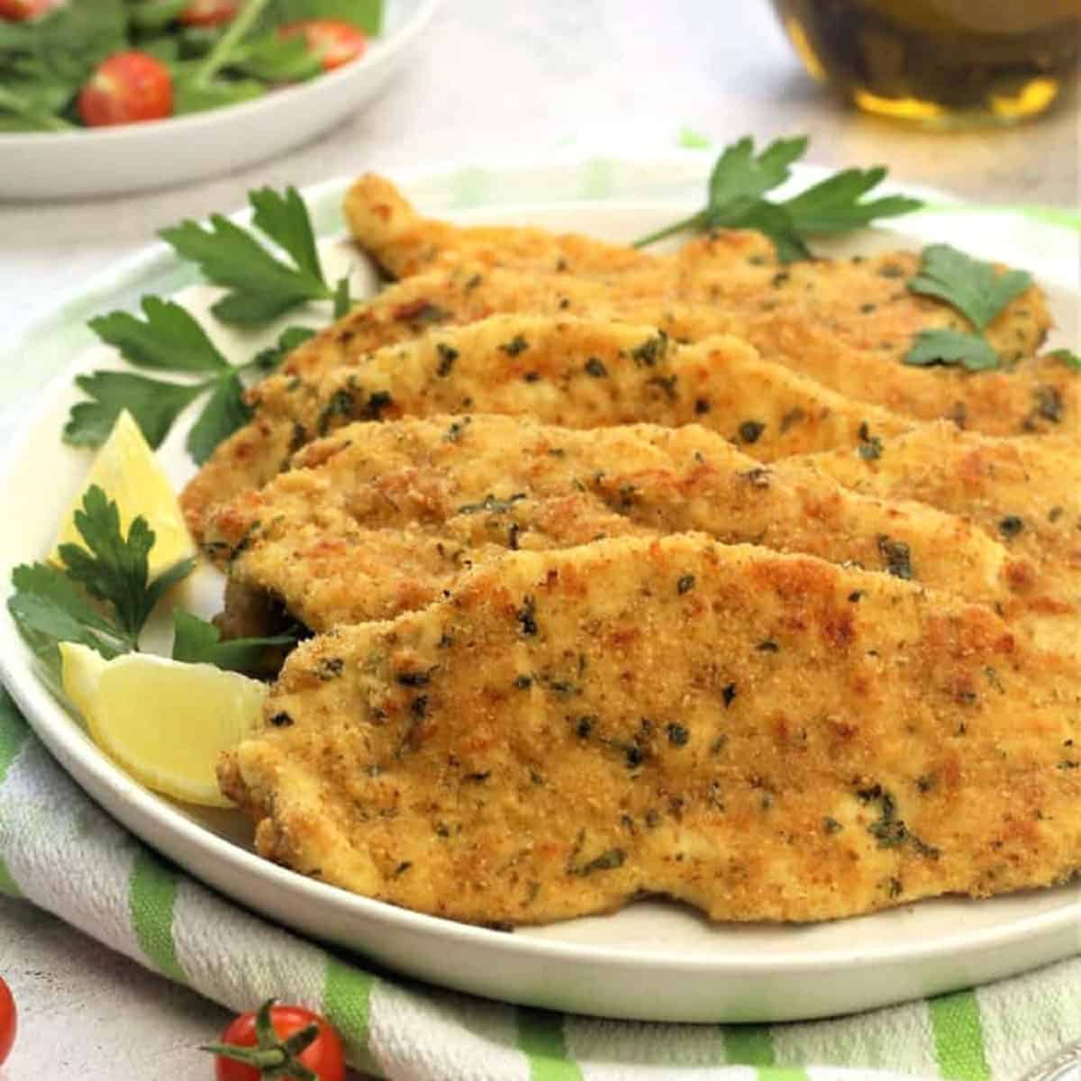 Breaded chicken cutlets on serving plate.