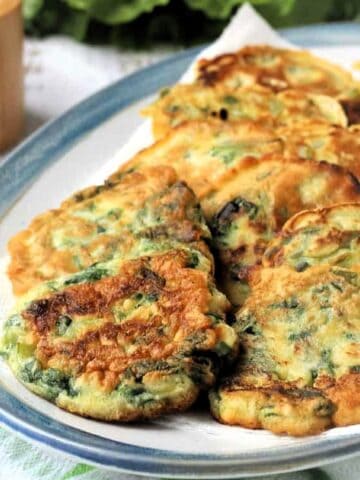 Fritters with swiss chard on serving plate.