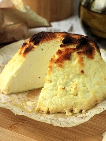 Baked ricotta with wedge cut out.