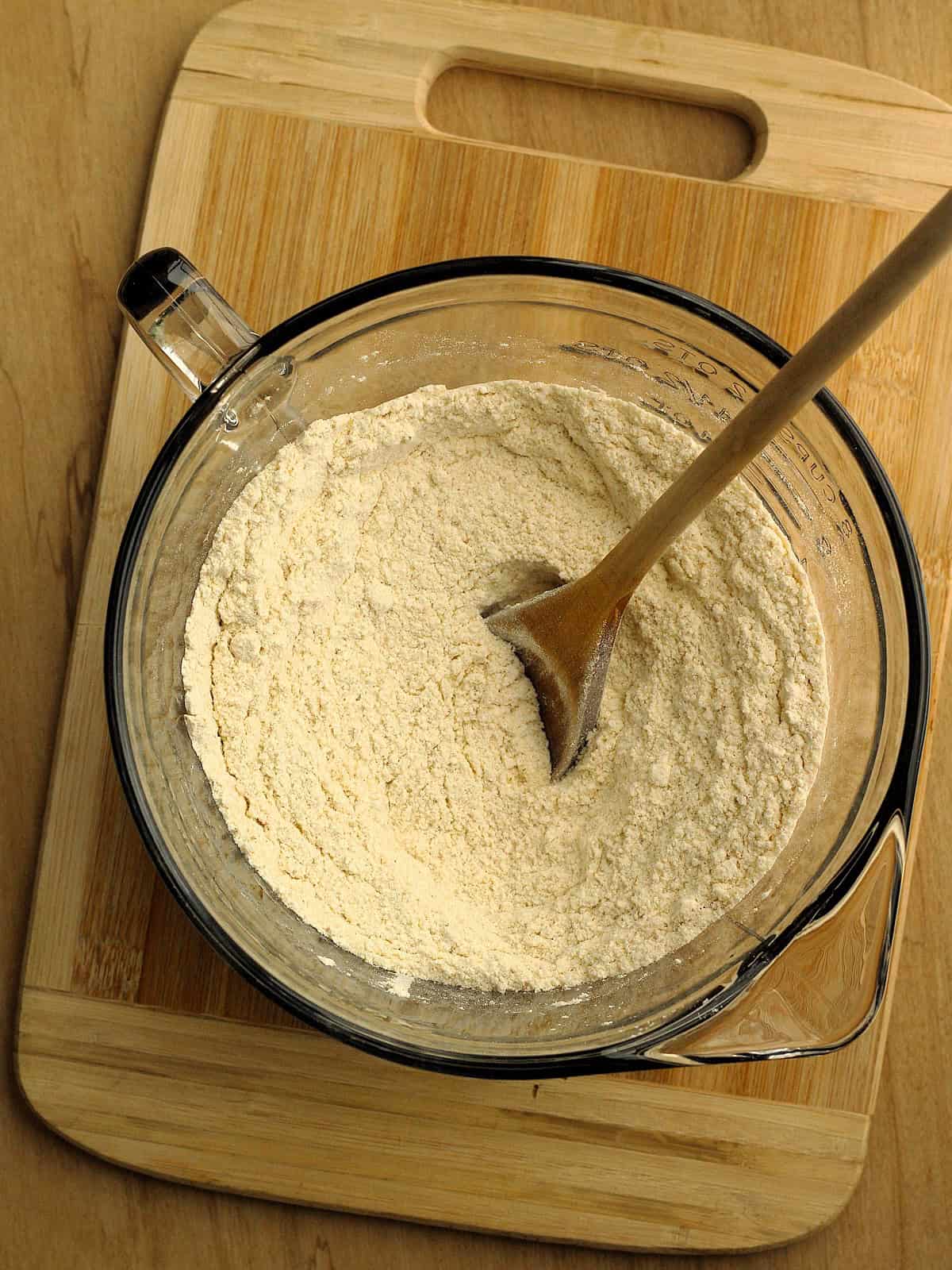 All-purpose flour, semolina flour and yeast stirred in large bowl for no-knead-pizza dough.