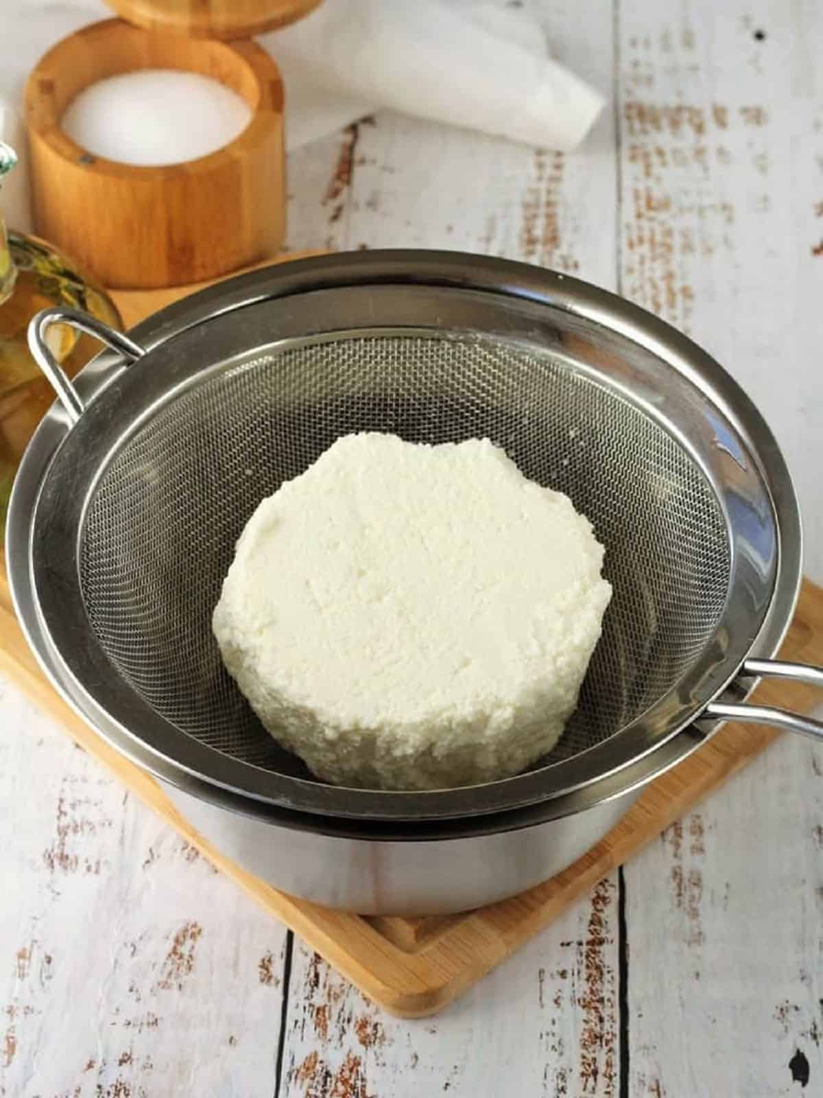 Ricotta drained in fine mesh sieve over bowl.