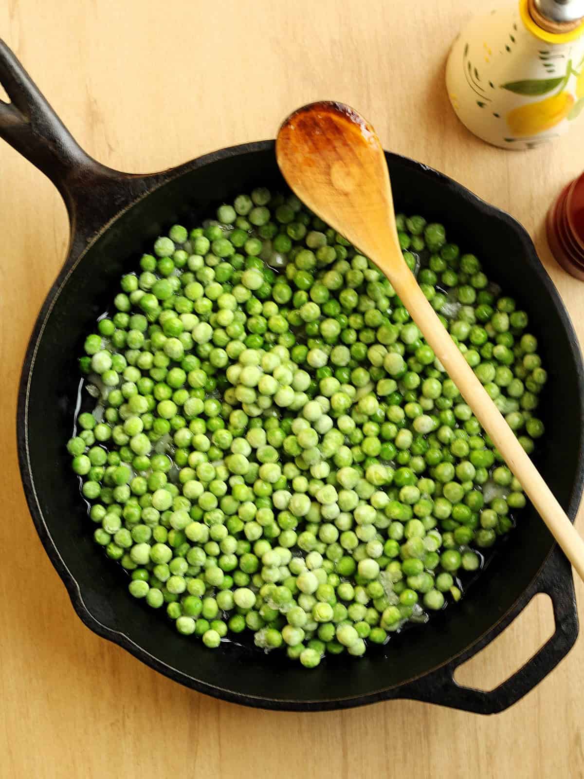 Sautéed peas and onion in cast iron skillet for frittata with peas recipe.