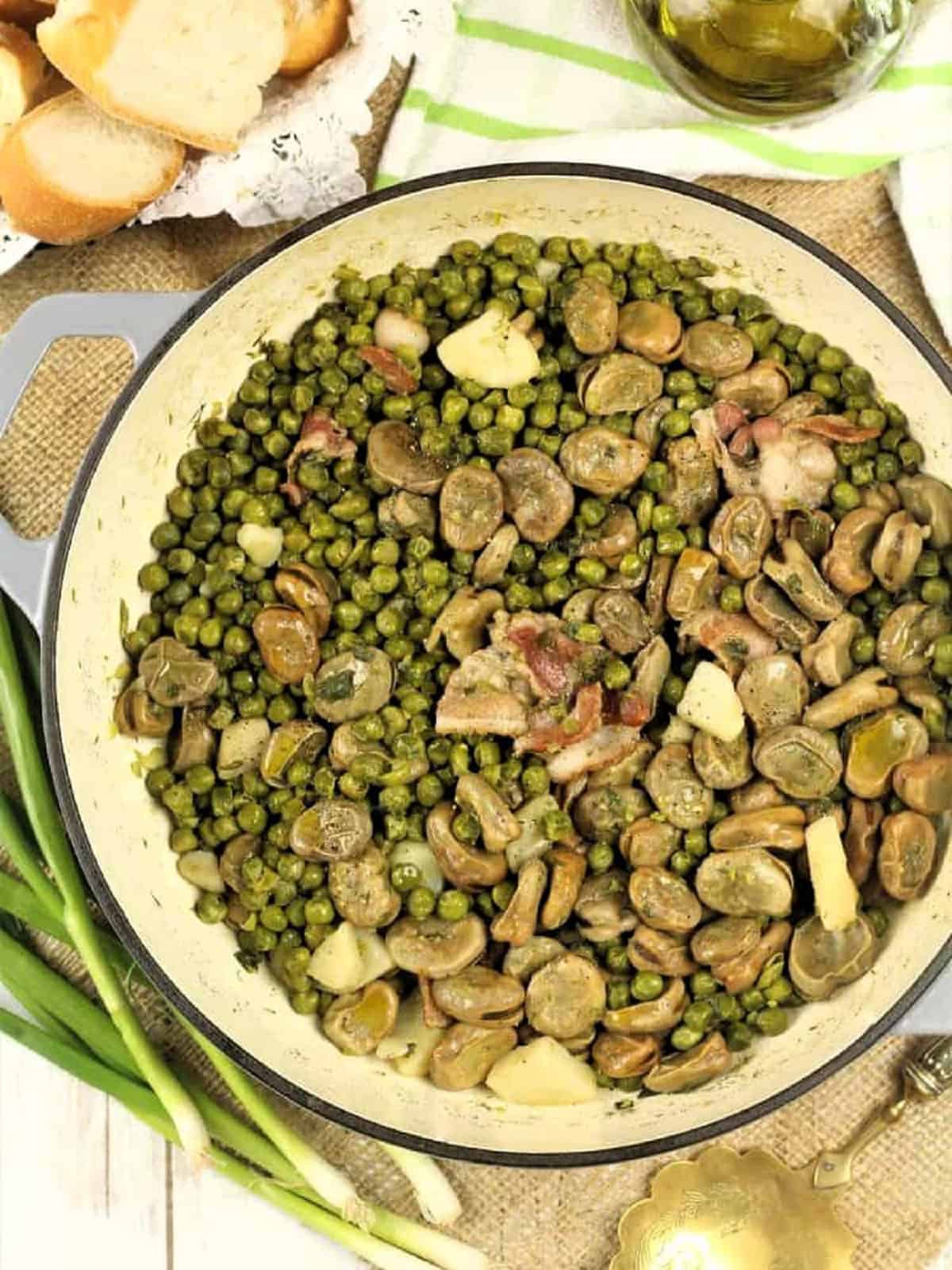 Spring vegetable stew with fava beans and peas in large skillet.