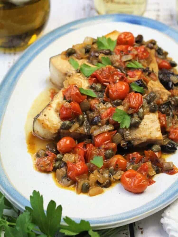 Swordfish topped with cherry tomatoes, olives and capers.