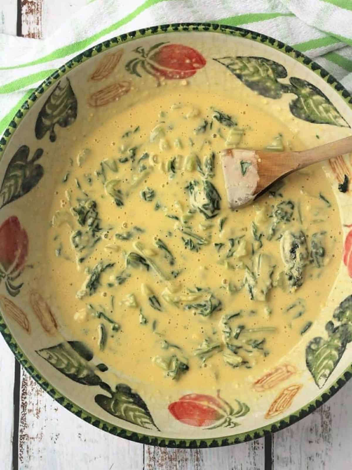 Swiss chard fritters batter stirred in large bowl.