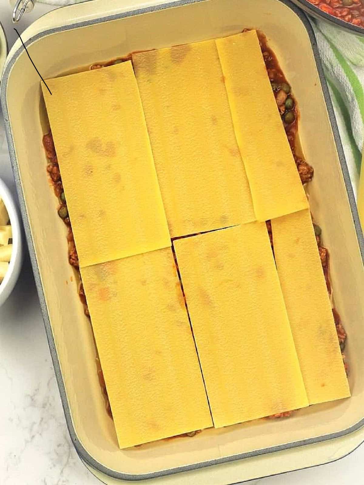 Lasagna sheets layered over casserole dish.