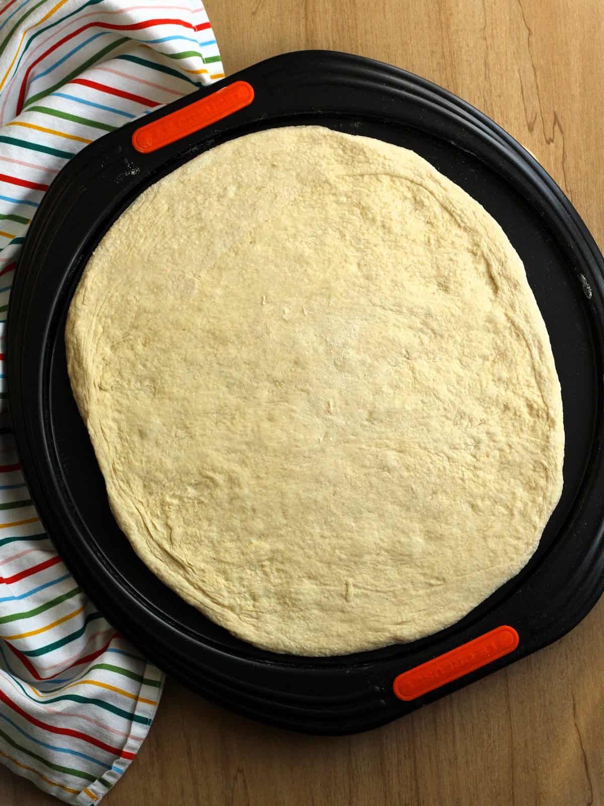 Flattened no-knead dough half for scacciata recipe.