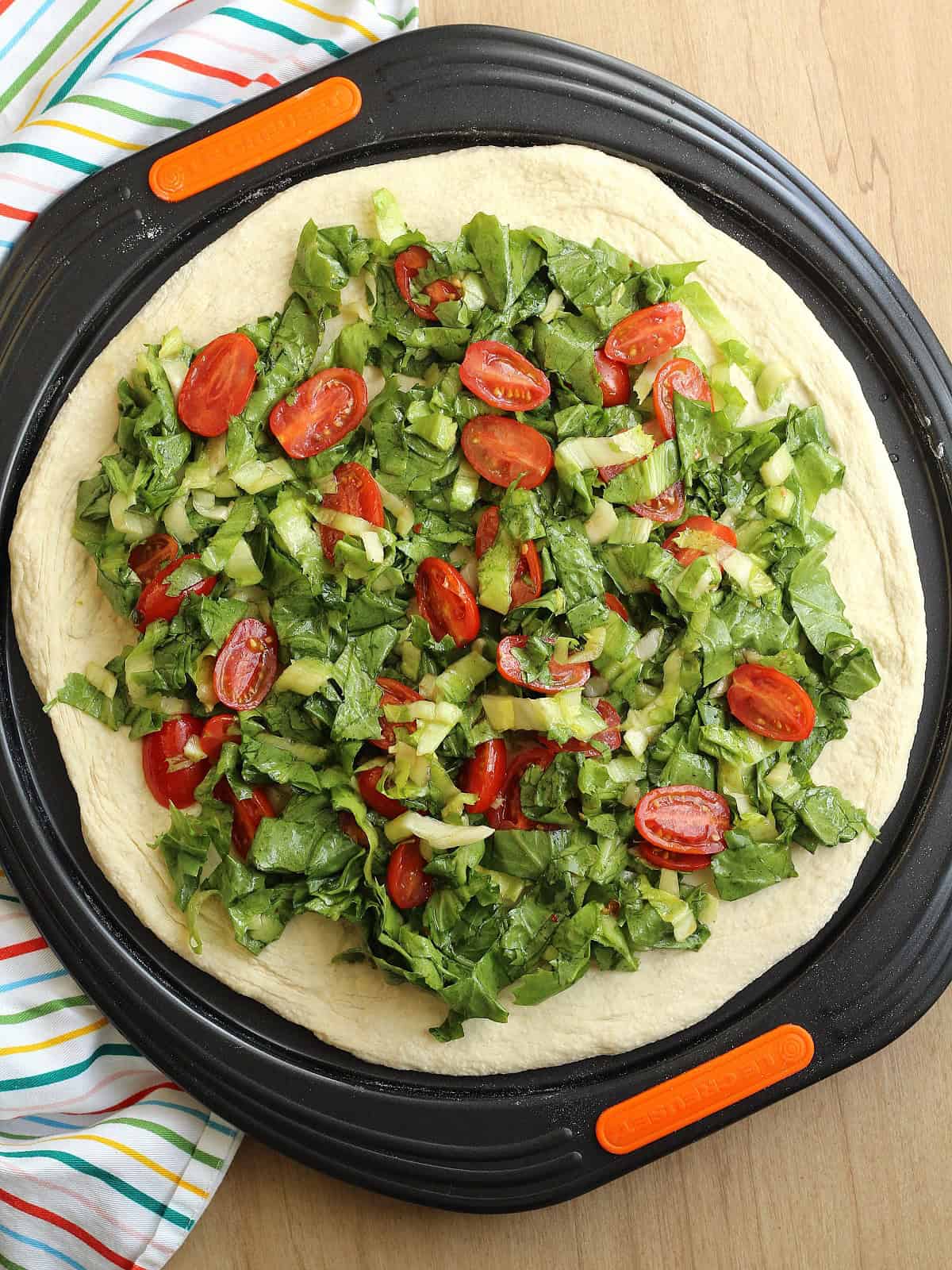 Scacciata dough topped with anchovies, escarole and cherry tomatoes.