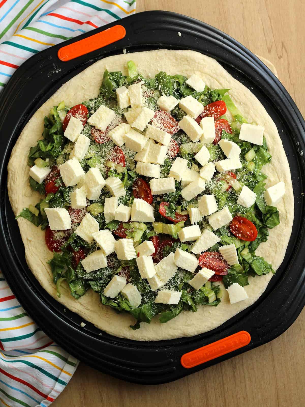 Scacciata Messinese topped with escarole, cherry tomatoes, tuma and Pecorino cheeses.