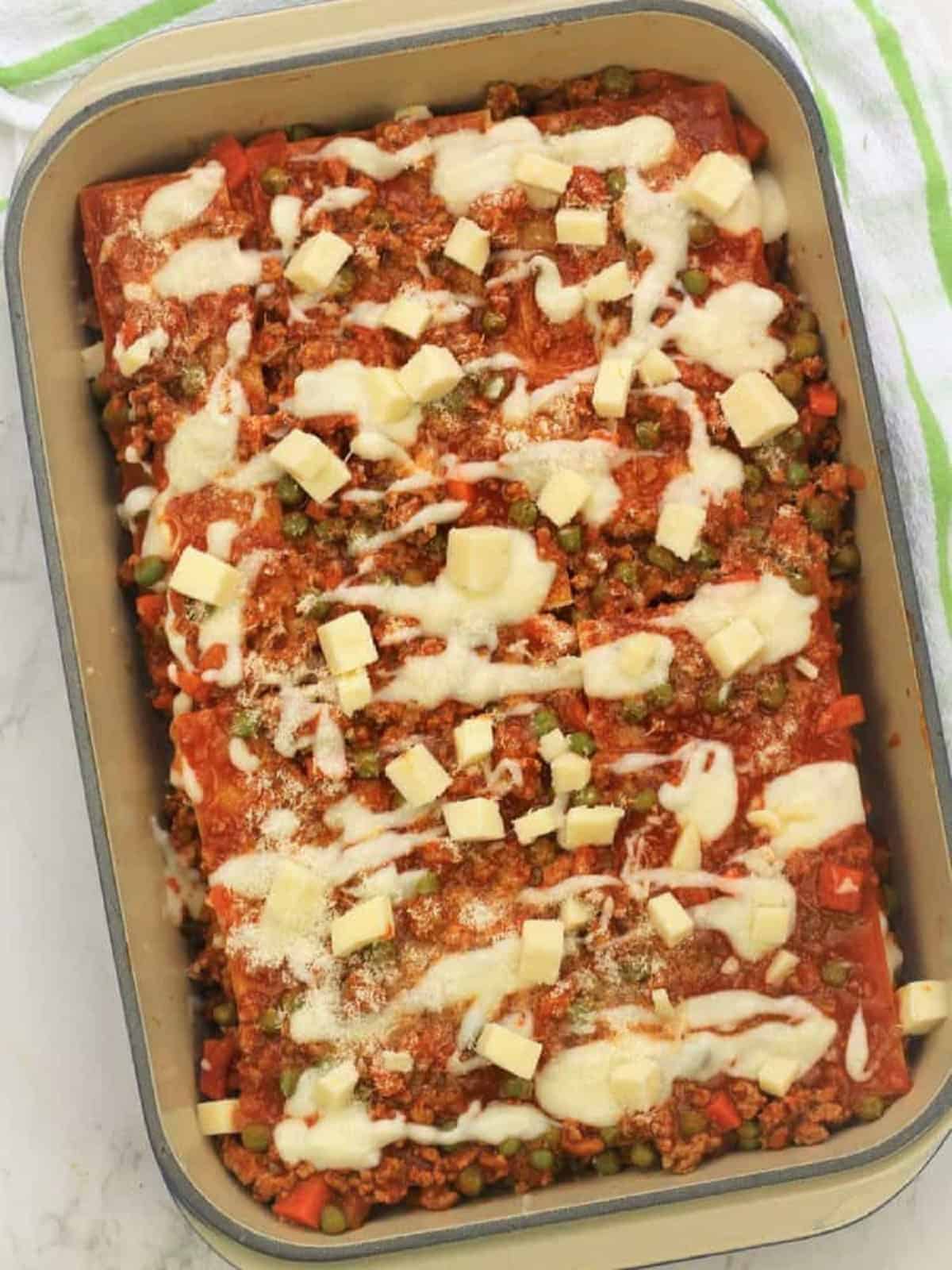 Lasagna topped with layer of béchamel sauce and mozzarella.