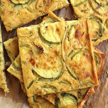 Italian chickpea flour flatbread with zucchini cut into squares and piled.