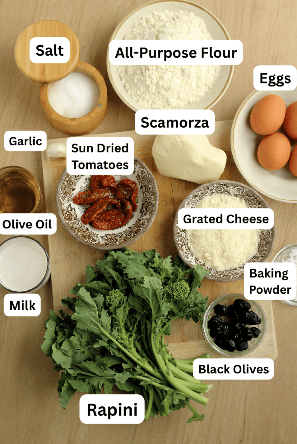 Ingredients for savory ring cake with rapini, sun dried tomatoes, black olives and scamorza cheese.