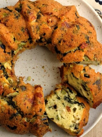 Savory bread ring filled with rapini cut open on plate.