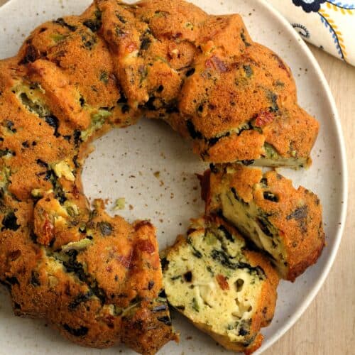 Savory bread ring filled with rapini cut open on plate.
