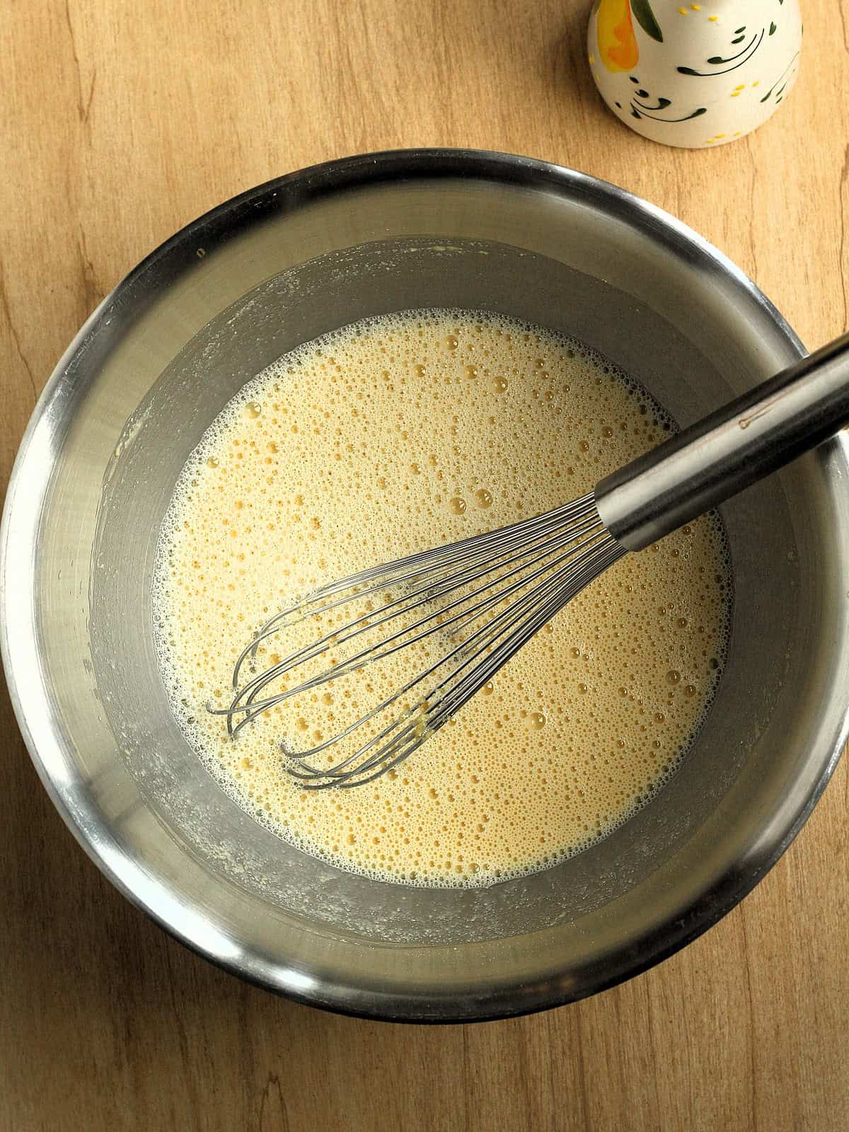 Chickpea flour whisked with water and salt in bowl for chickpea flatbread recipe.