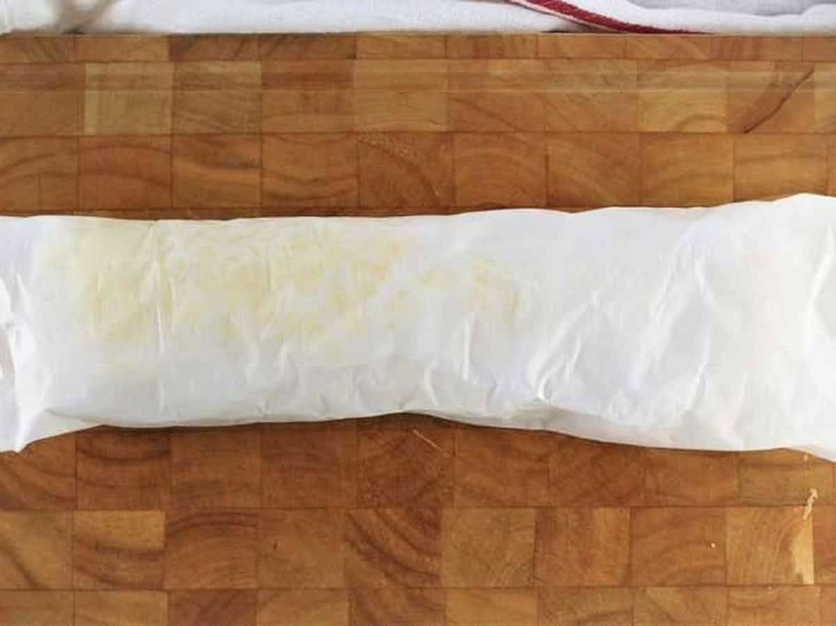 Cake roll sponge wrapped in parchment paper to cool.