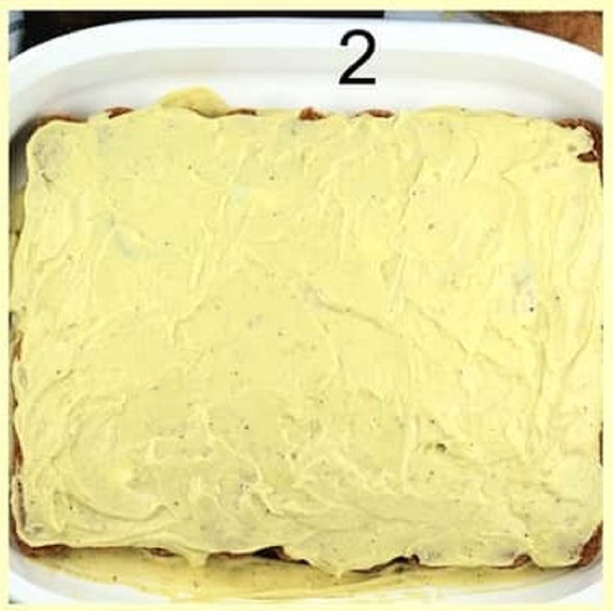 Layer of pistachio mascarpone cream spread over lady fingers for tiramisu recipe.