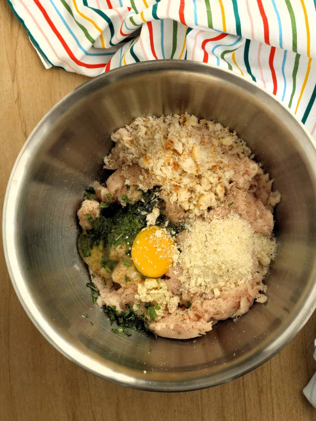 Swordfish mixture in bowl with egg, breadcrumbs, cheese and parsley.