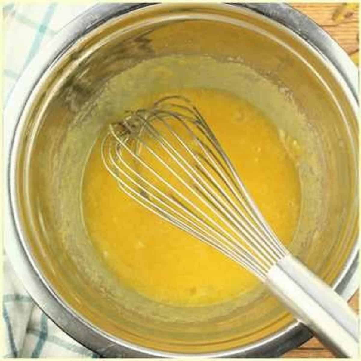 Whisked egg yolks and sugar in bowl for tiramisu cream.
