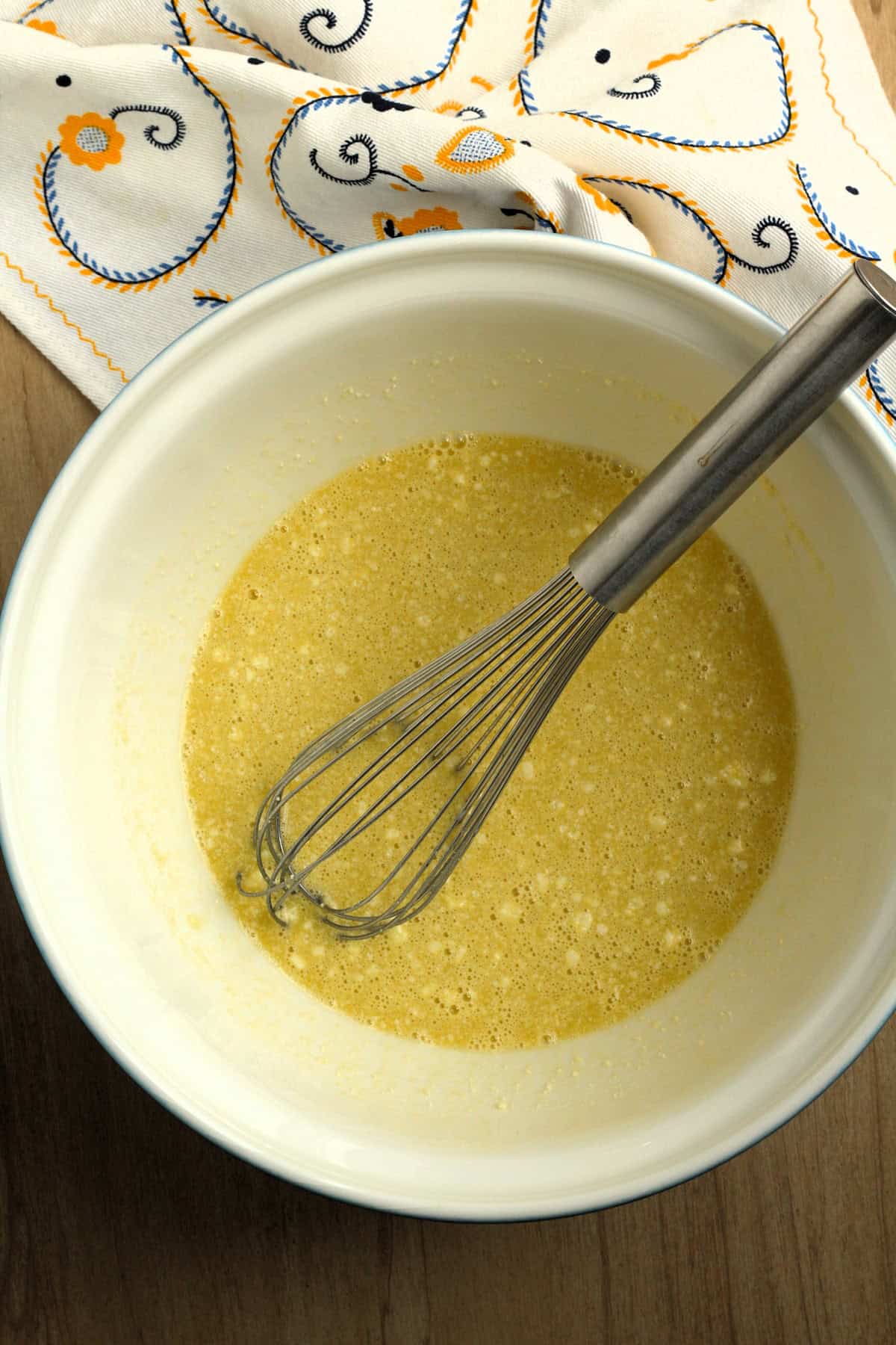 Batter for savory ring cake recipe in bowl with whisk.