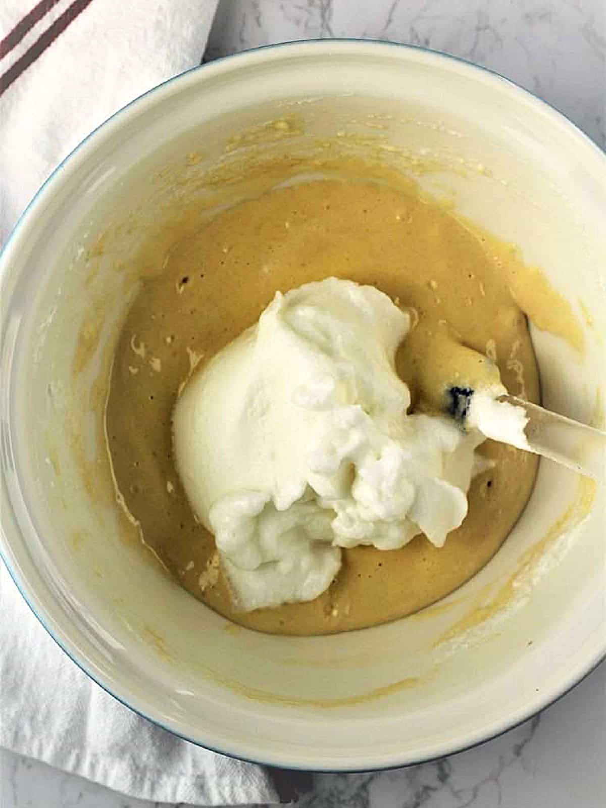 Egg whites folded into cake batter for roll cake recipe.