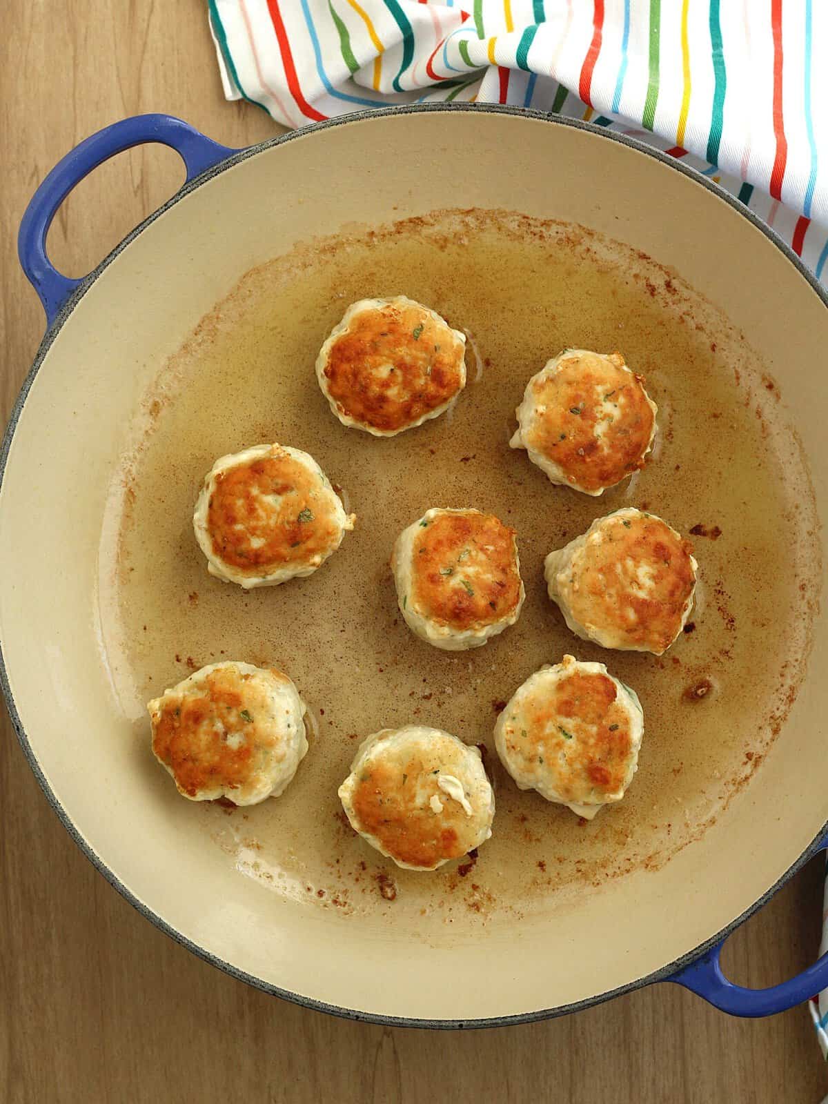 Browned swordfish meatballs in skillet.