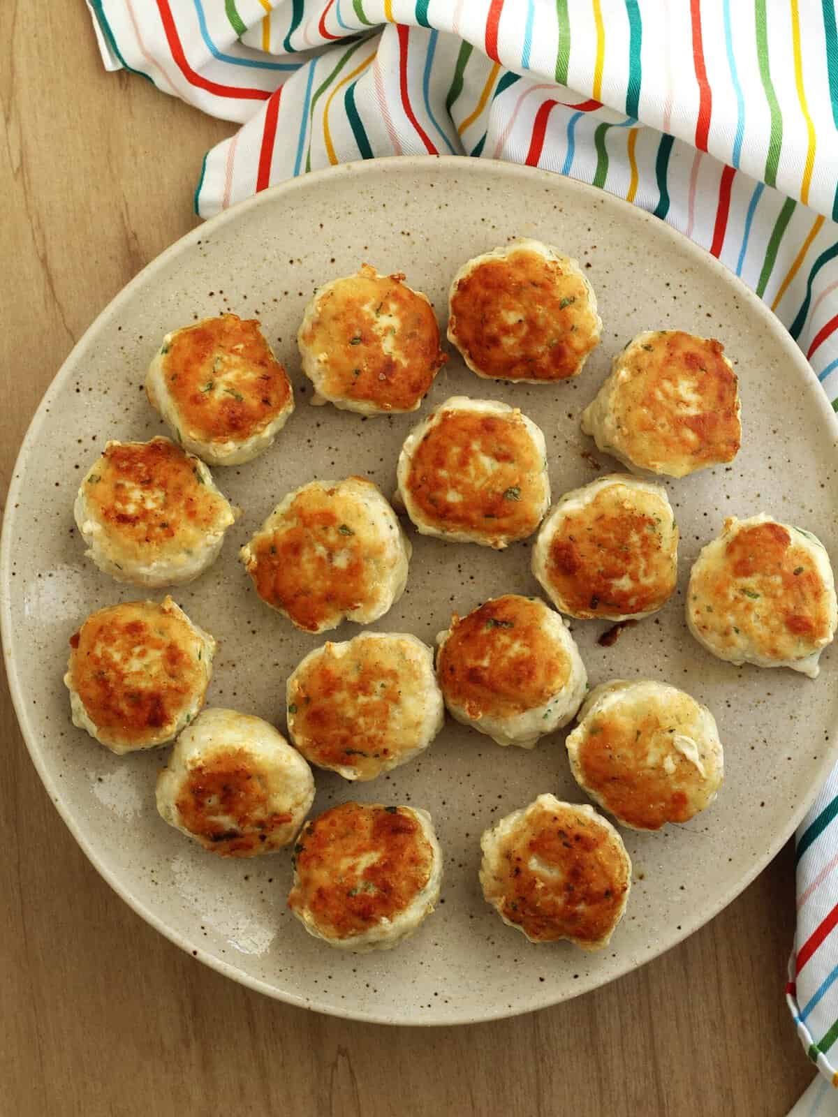 Browned swordfish meataballs on a plate.