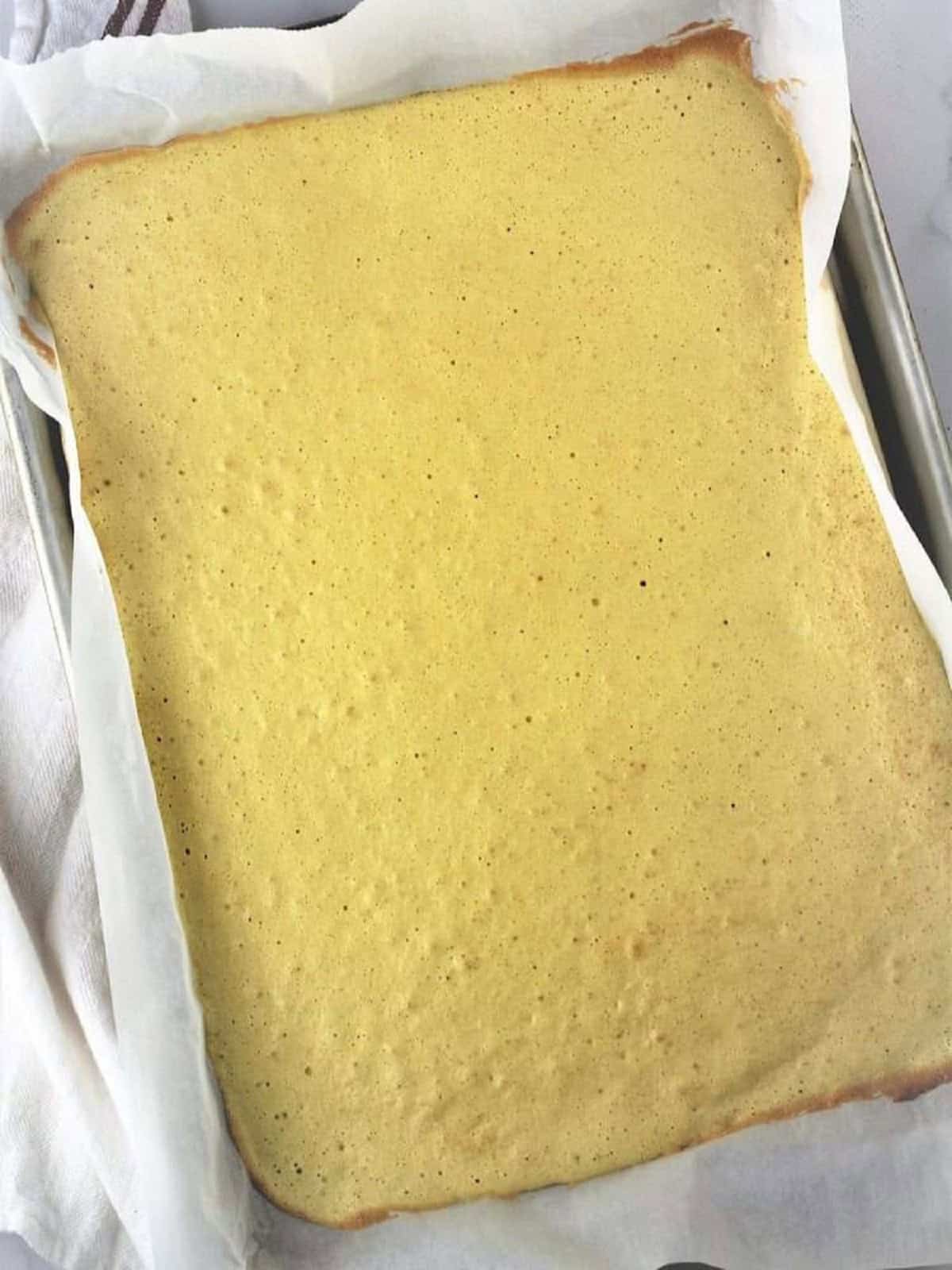 Baked sponge for cake roll in baking sheet.
