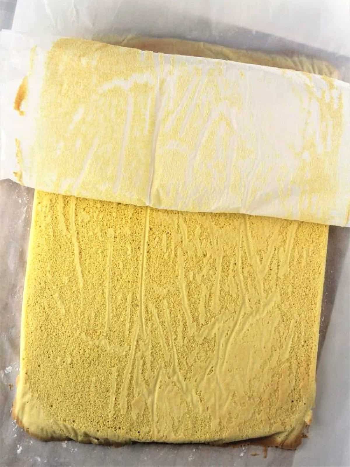 Flat sponge cake on parchment paper for roll cake.