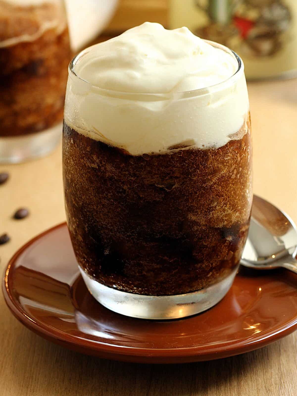 Sicilian coffee granita in glass topped with whipped cream.